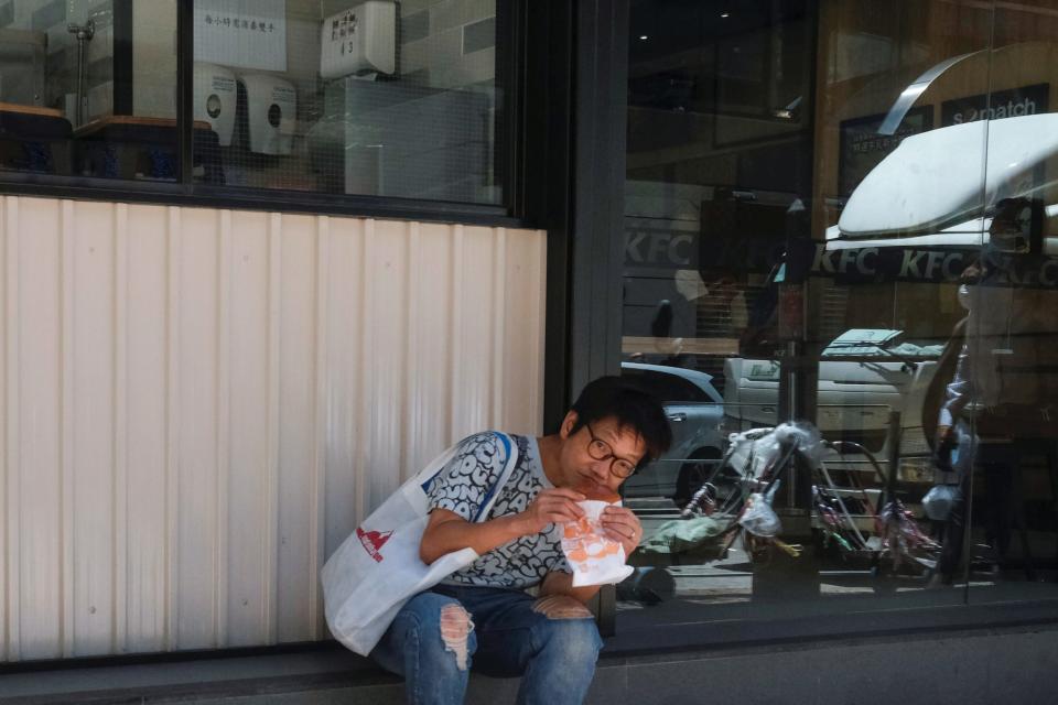 A woman has lunch outside a restaurant at a mall after the government banned dine-in services, following the coronavirus disease (COVID-19) outbreak in Hong Kong, China July 30, 2020. REUTERS/Tyrone Siu