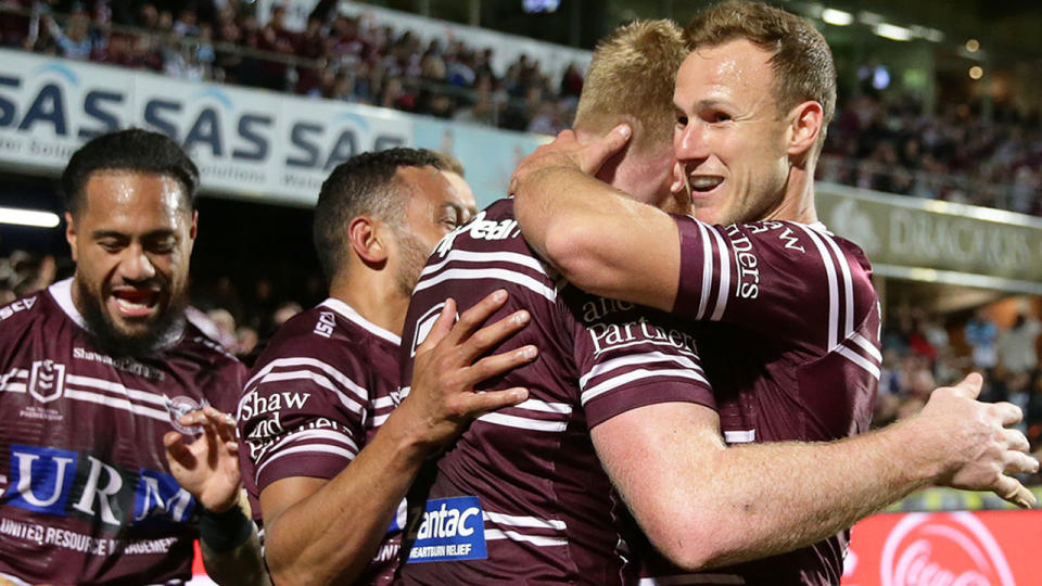 Pictured right, Manly captain Daly Cherry-Evans celebrates with teammate Brad Parker.