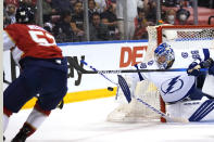 Tampa Bay Lightning goaltender Andrei Vasilevskiy turns away the puck in front of Florida Panthers defenseman MacKenzie Weegar, left, during the second period in Game 2 of an NHL hockey Stanley Cup first-round playoff series Tuesday, May 18, 2021, in Sunrise, Fla. (AP Photo/Lynne Sladky)