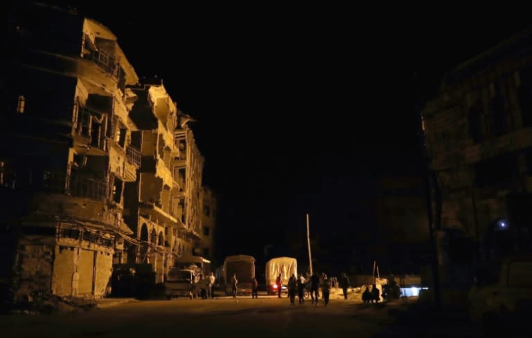 People unload supplies from a Syrian Arab Red Crescent (SARC) truck part of a SARC and UN aid convoy in the rebel-held town of Douma, on the eastern outskirts of Damascus, early on May 3, 2017