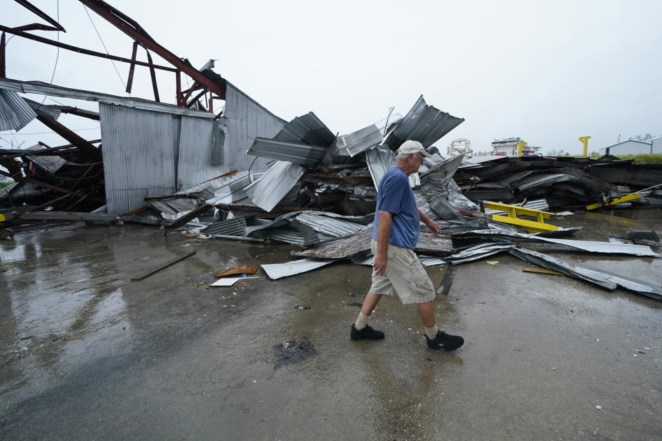 Steven Voisin walks past some of the destruction of his oyster processing plant, in the aftermath of Hurricane Ida in Houma, La., Tuesday, Sept. 14, 2021. Voisin said he has yet to compute a dollar estimate for damage to the company, which also operates boats that harvest oysters, but it's substantial. (AP Photo/Gerald Herbert)