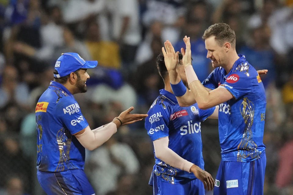 Mumbai Indians' captain Rohit Sharma, left, and Mumbai Indians' Jason Behrendorff celebrate the wicket of Gujrat Titans' captain Hardik Pandya during the Indian Premier League cricket match between Mumbai Indians and Gujrat Titans in Mumbai, India, Friday, May 12, 2023. (AP Photo /Rajanish Kakade)