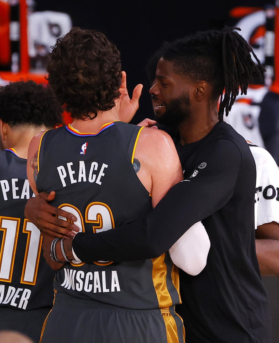 Nerlens Noel hugs Mike Muscala, left, of the Oklahoma City Thunder after Muscala hit the game-winning three-point basket against the Miami Heat during the second half of an NBA basketball game Wednesday, Aug. 12, 2020, in Lake Buena Vista, Fla. (Kevin C. Cox/Pool Photo via AP)