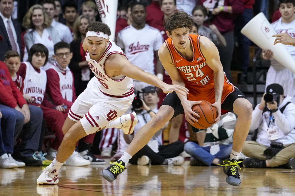 Illinois forward Matthew Mayer (24) picks up a loose ball in front of Indiana forward Race Thompson (25) in the first half of an NCAA college basketball game in Bloomington, Ind., Saturday, Feb. 18, 2023. (AP Photo/Michael Conroy)