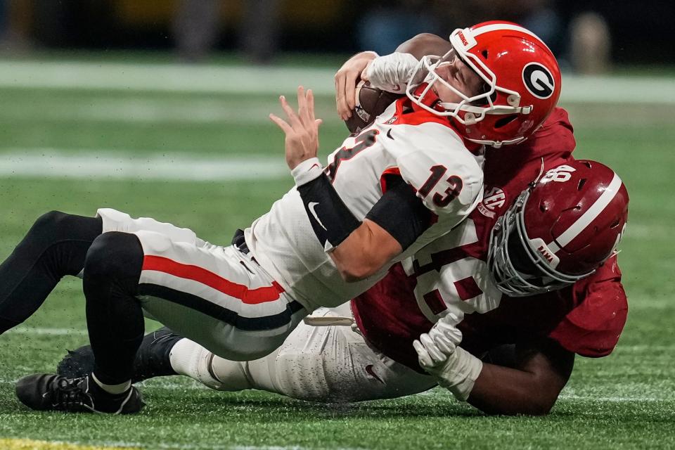 Georgia quarterback Stetson Bennett is tackled for a loss by Alabama defensive lineman Phidarian Mathis 
during the second half of the SEC championship game.