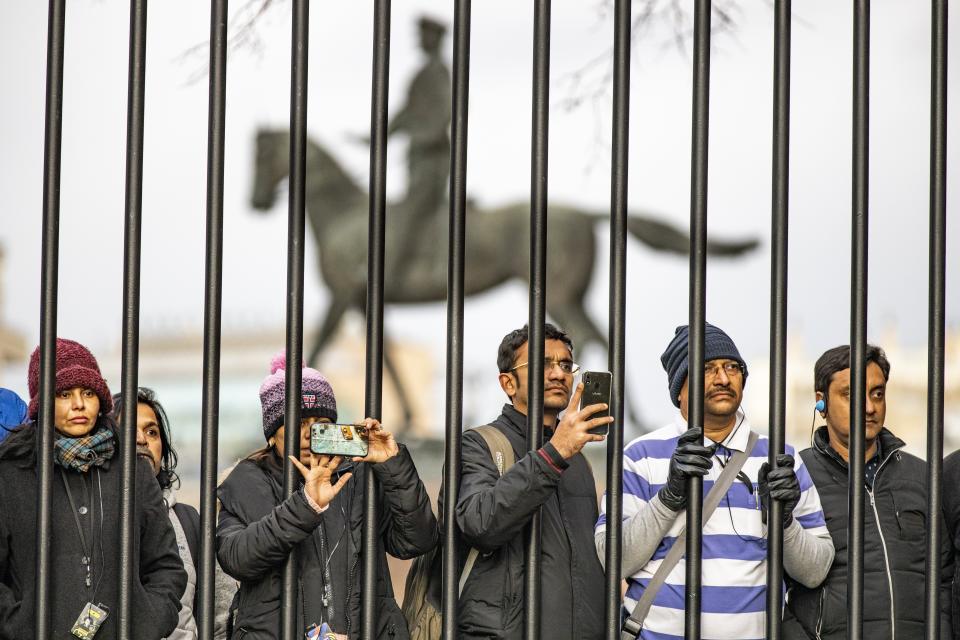 Tourists take pictures during the Kremlin guards is changing with the monument of Soviet Marshal Georgy Zhukov in the background in Manezhnaya Square near the Kremlin in Moscow, Russia, Wednesday, Feb. 19, 2020. (AP Photo/Alexander Zemlianichenko)