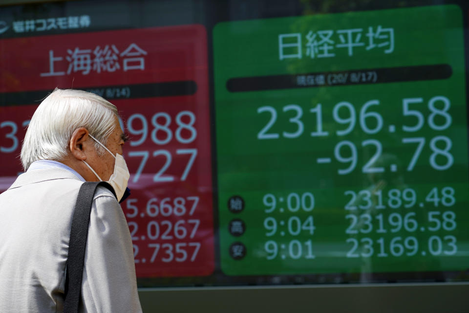 A man looks at an electronic stock board showing Japan's Nikkei 225 index at a securities firm in Tokyo Monday, Aug. 17, 2020. Japanese stocks sank while other Asian markets gained Monday after Japan reported a record economic contraction as the coronavirus pandemic weighed on retailing, investment and exports. (AP Photo/Eugene Hoshiko)