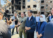 In this photo released by the Press and Media Bureau of the Indonesian Presidential Palace, Indonesian President Joko Widodo, center, and his wife Iriana, right, talk to the media near an apartment building damaged by shelling, during his visit in the town of Irpin on the outskirts of Kyiv, Ukraine on Wednesday, June 29, 2022. (Laily Rachev, Indonesian Presidential Palace via AP)