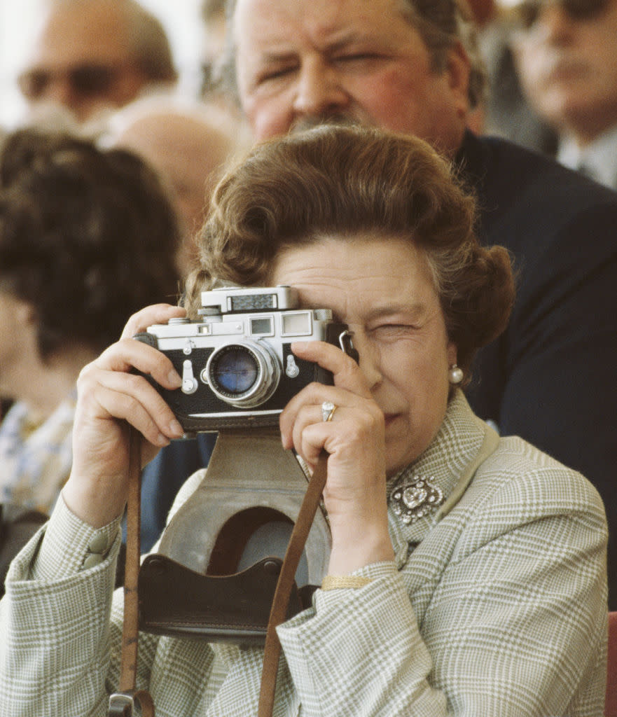WINDSOR, UNITED KINGDOM - MAY 16:  Queen Elizabeth II At The Windsor Horse Show, May 16, 1982. She Is Taking Pictures Of Her Husband With Her Leica M3 Camera, Wearing Her Engagement Ring And The Cullinan V Diamond Heart Brooch.  (Photo by Tim Graham Photo Library via Getty Images)