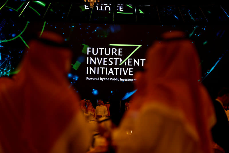 Participants look at a sign of the Future Investment Initiative during the investment conference in Riyadh, Saudi Arabia October 23, 2018. REUTERS/Faisal Al Nasser