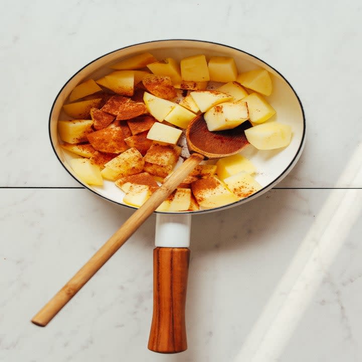 Apples cooking in a saucepan with cinnamon