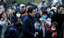 People take pictures of Japan's Prime Minister Shinzo Abe as he attends a Friday night concert outside a museum in Tokyo, Japan February 24, 2017. REUTERS/Toru Hanai