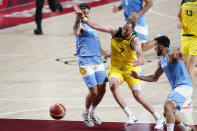 Australia's Joe Ingles (7) loses the ball between Argentina's Nicolas Laprovittola (8) and Facundo Campazzo, right, during a men's basketball quarterfinal round game at the 2020 Summer Olympics, Tuesday, Aug. 3, 2021, in Saitama, Japan. (AP Photo/Charlie Neibergall)