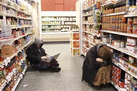 People rest at the aisle of a Publix grocery store after being stranded due to a snow storm in Atlanta, Georgia, January 29, 2014. REUTERS/Tami Chappell