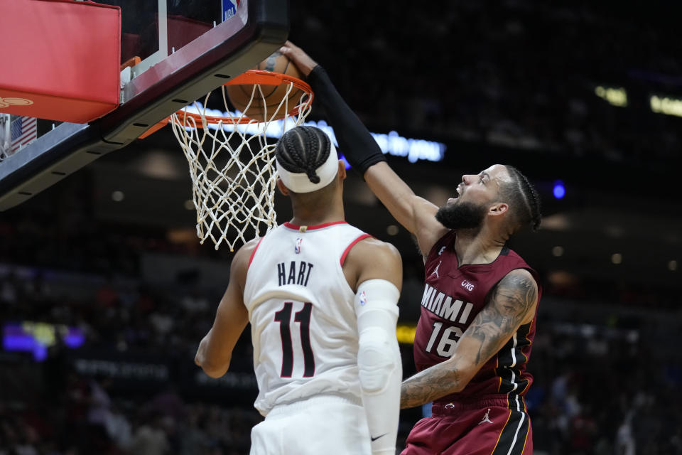 Miami Heat forward Caleb Martin (16) dunks the ball against Portland Trail Blazers guard Josh Hart (11) during the second half of an NBA basketball game, Monday, Nov. 7, 2022, in Miami. (AP Photo/Wilfredo Lee)