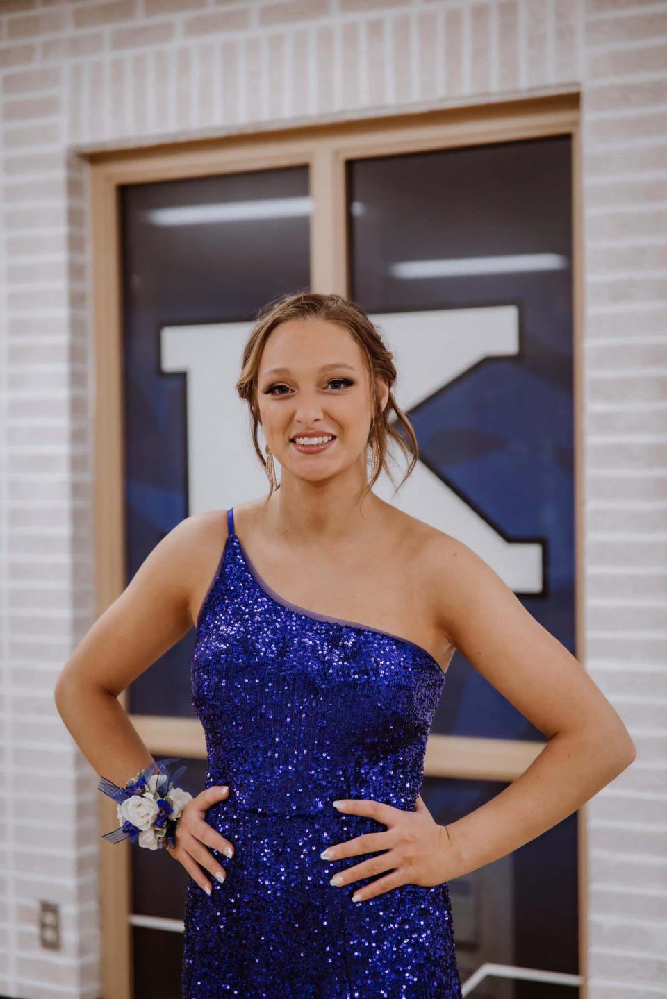 Addie Shelton strikes a pose showing off her Sherry Hill “Karns Blue” sequined gown just before taking the field for homecoming at Karns High School Friday, Sept. 15, 2023.