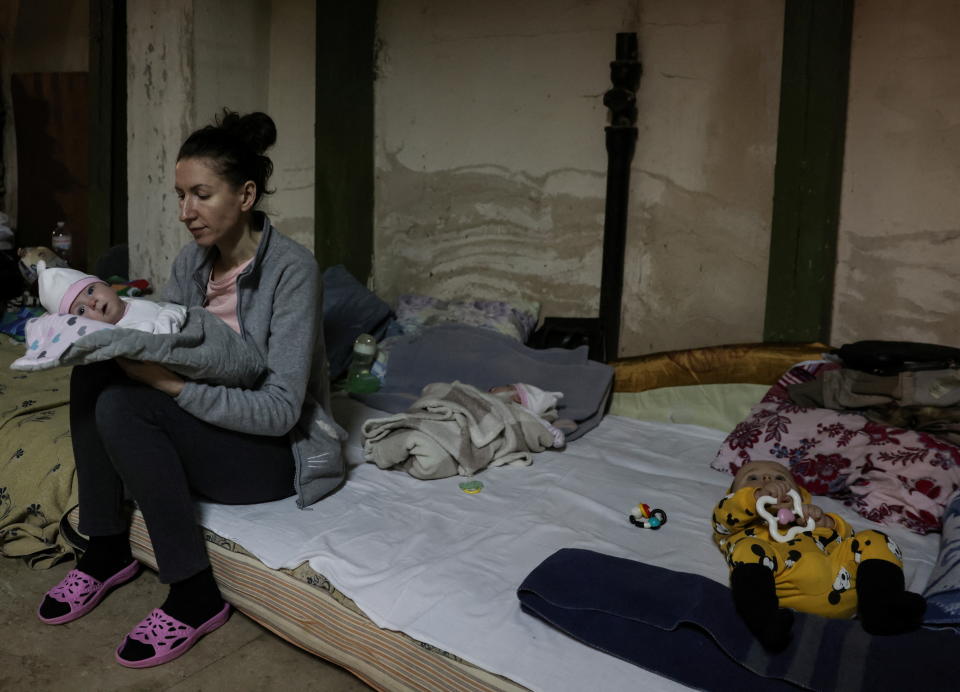 A woman with a baby sits on a mattress in one of the shelters of Okhmadet Children's Hospital, as Russia's invasion of Ukraine continues, in Kyiv, Ukraine February 28, 2022. REUTERS/Umit Bektas