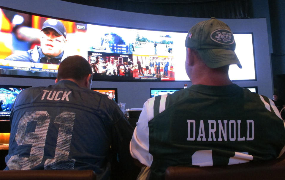 FILE: This Sept. 9, 2018 file photo shows fans of the New York Giants and Jets watching a football game after placing bets in the sports betting lounge at the Ocean Casino Resort in Atlantic City, N.J. The American Gaming Association projects that 45.2 million Americans will bet on the NFL this season. (AP Photo/Wayne Parry, FILE)