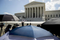 Bill Christeson holds up a sign that reads "Follow the Money" outside the Supreme Court, Thursday, July 9, 2020, in Washington. The Supreme Court ruled Thursday that the Manhattan district attorney can obtain Trump tax returns while not allowing Congress to get Trump tax and financial records, for now, returning the case to lower courts. (AP Photo/Andrew Harnik)