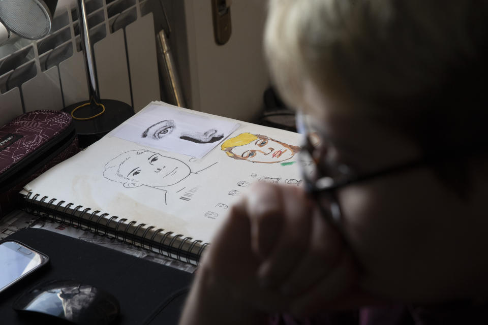 A self portrait on the desk as Matteo listens to a virtual school lesson in his room in Rome, Thursday, March 18, 2021. Matteo is an 18-year-old student who identifies as a man and is in the process of changing his legal gender from female to male. The Ripetta school of art in Rome - where he studies - recently joined a handful of high schools in Italy that give transgender students the right to be known by a name other than the one they were given at birth. The initiative is meant to create an environment where transgender students feel secure and reflects a growing awareness in Italy of gender dysphoria among teenagers and children. (AP Photo/Alessandra Tarantino)