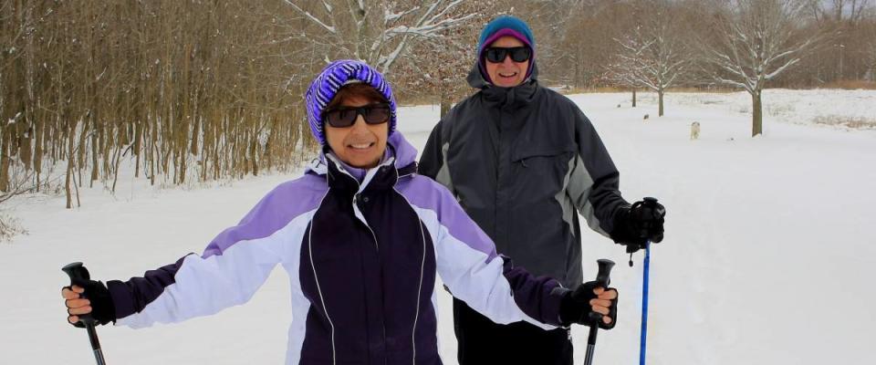 Senior couple skiing cross-country in the field