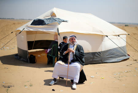 A Palestinian man sits outside a tent during a tent city protest along the Israel-Gaza border, demanding the right to return to their homeland, in the southern Gaza Strip April 1, 2018. REUTERS/Ibraheem Abu Mustafa