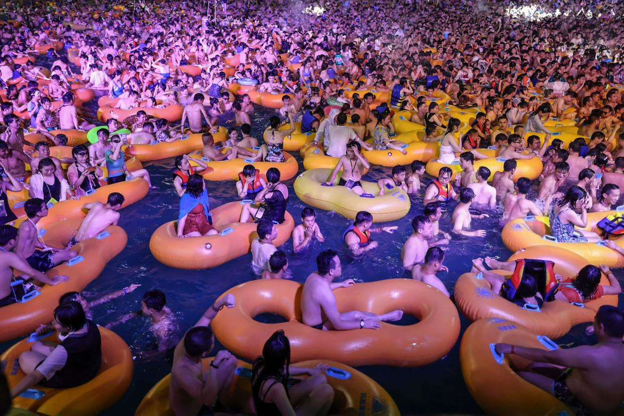 TOPSHOT - This photo taken on August 15, 2020 shows people watching a performance as they cool off in a swimming pool in Wuhan in China's central Hubei province. (Photo by STR / AFP) / China OUT (Photo by STR/AFP via Getty Images)