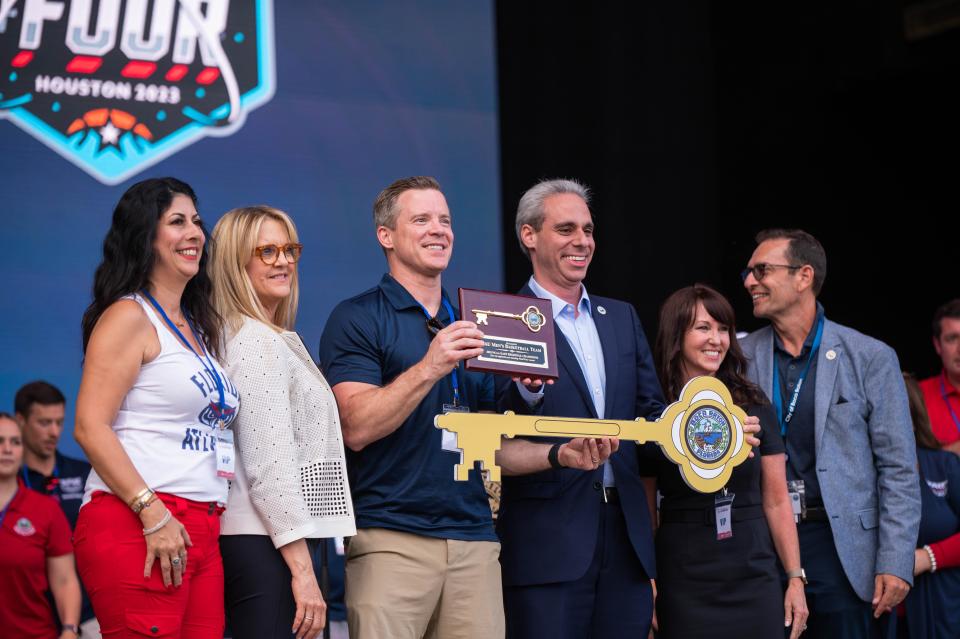 Florida Atlantic men's basketball team head coach Dusty May, center, poses for a picture with Boca Raton City Councilors Yvette Drucker, left, Monica Mayotte, Mayor Scott Singer, and Councilors Fran Nachlas and Marc Wigder, while holding a ceremonial key to the city of Boca Raton at the Mizner Park Amphitheater on Wednesday, April 19, 2023, in Boca Raton, Fla. Hundreds of Florida Atlantic fans gathered in Mizner Park to celebrate the FAU men's basketball team's accomplishments during the 2022-2023 season, including an appearance in the NCAA Tournament Final Four.