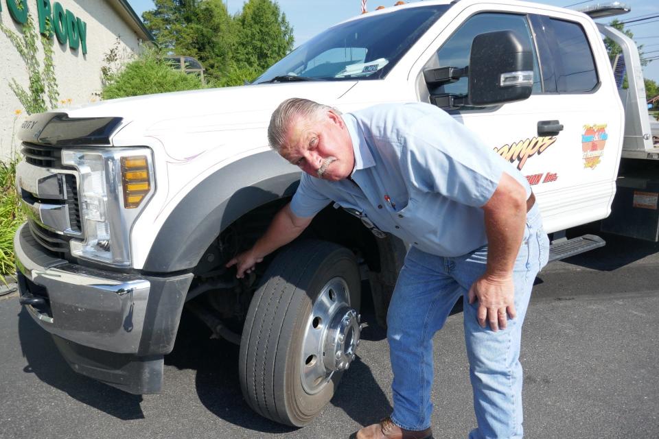 Jeff Bryan, owner of Swamp's Auto Works in Ottsville, shows the front end of his tow truck that he's had to fix twice, he said, due to it hitting bumps on Route 611.