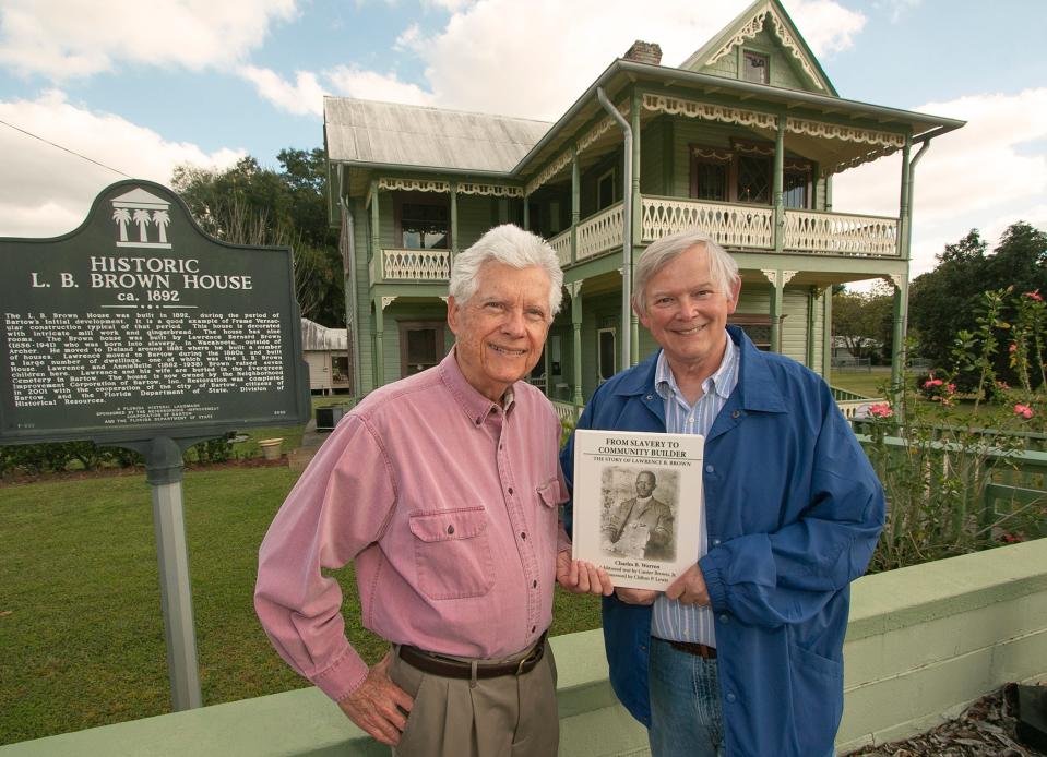 Charles B. Warren, left, and Canter Brown Jr., pose with the newly published book, "From Slavery To Community Builder," in front of the L.B. Brown House in Bartow. Warren wrote the book, and Brown contributed the opening chapter. Warren will be at the Polk County History Center on Saturday for a book signing.
