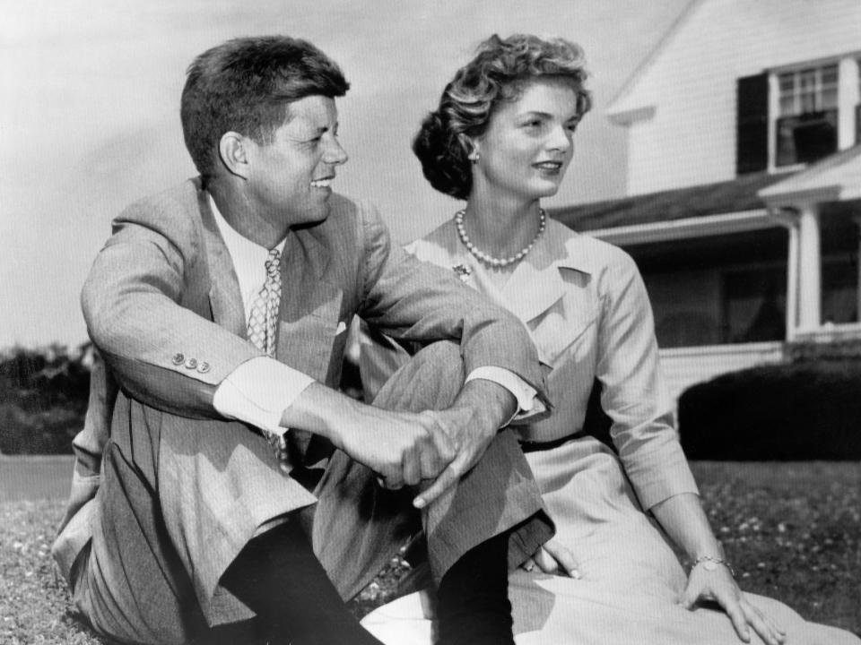 John F. Kennedy and Jackie Kennedy sitting on the grass.