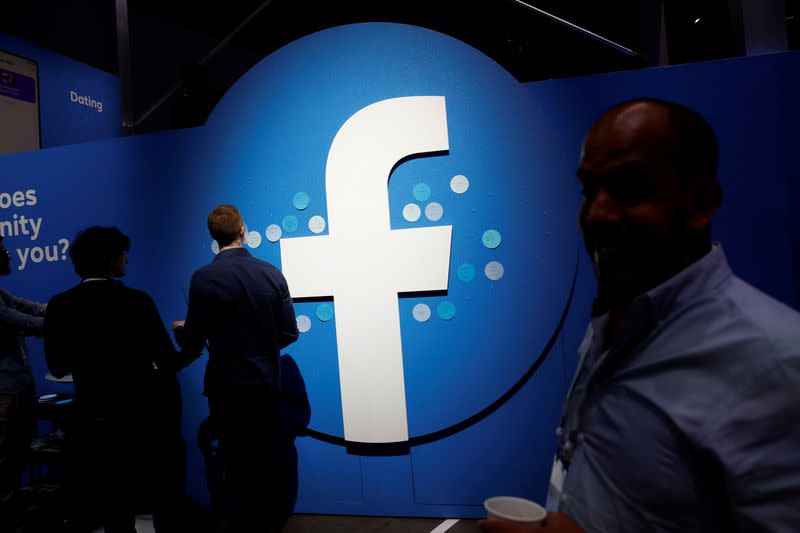 FILE PHOTO: Attendees walk past a Facebook logo during Facebook Inc's F8 developers conference in San Jose