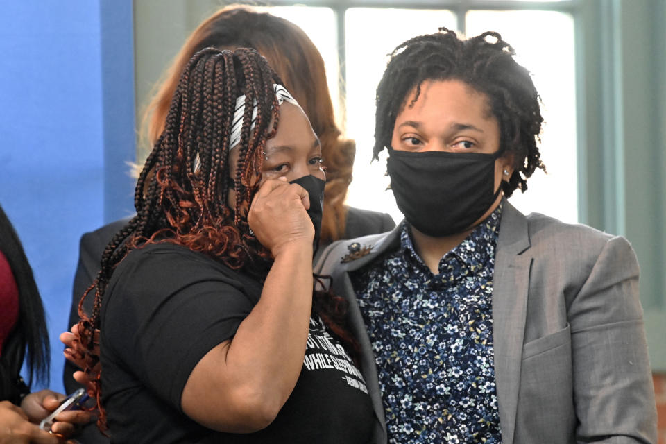 Tamika Palmer, the mother of Breonna Taylor, left, wipes a tear from her eye following the signing of a partial ban on no-knock warrants at the Center for African American Heritage Louisville, Ky., Friday, April 9, 2021. The bill signing comes after months of demonstrations set off by the fatal shooting of Taylor in her home during a botched police raid. (AP Photo/Timothy D. Easley)