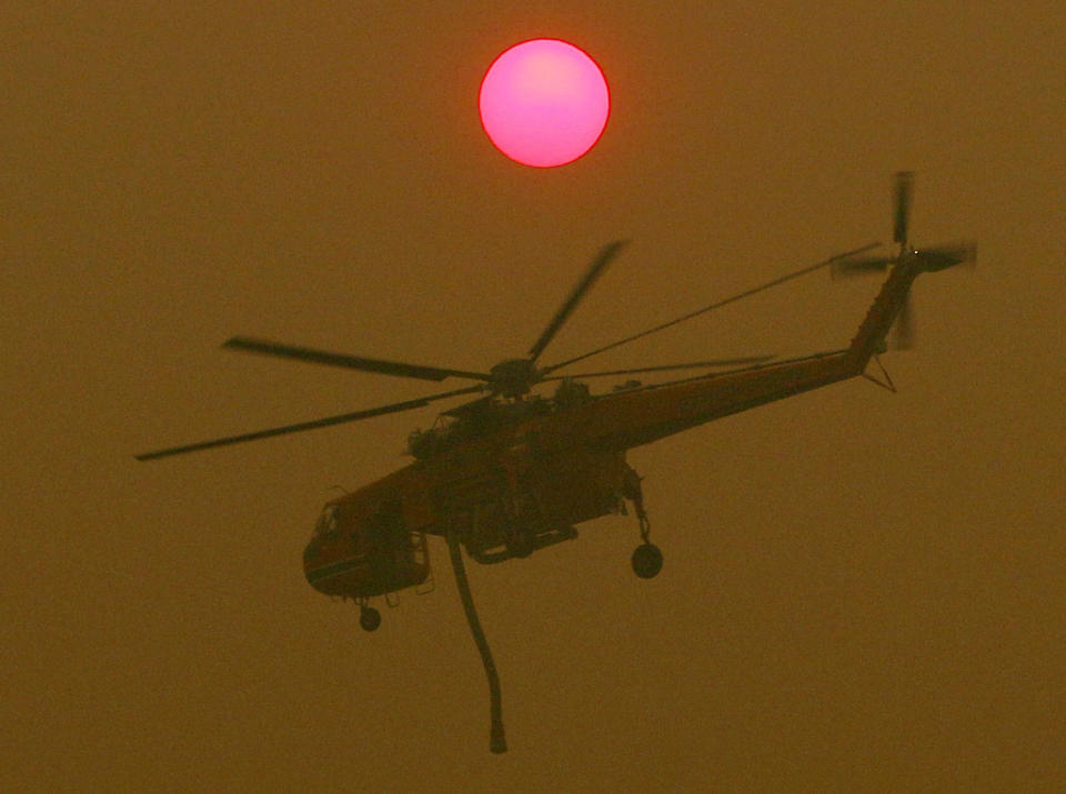 A Skycrane is seen over an out of control fire at Avery's lane, near Stanford Merthyr, west of Newcastle, Tuesday, December 3, 2019. (AAP Image/Darren Pateman) NO ARCHIVING