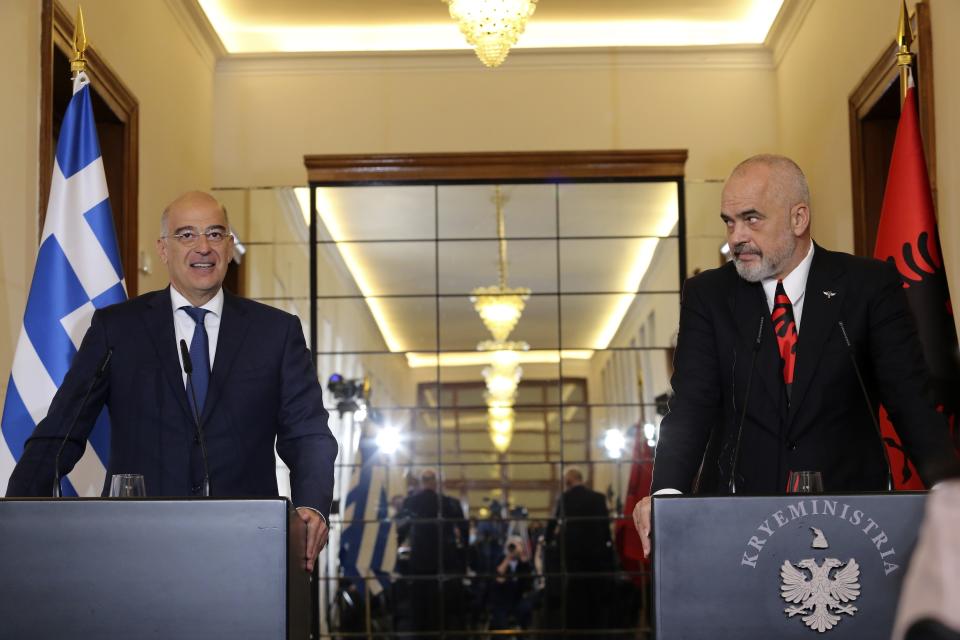 Greek Foreign Minister Nikos Dendias, left, makes a statement with the Albanian Prime Minister Edi Rama in Tirana, Tuesday, Oct. 20, 2020. Bilateral issues and maritime border delimitation in the Ionian Sea were the main topics of their discussion. (AP Photo/Hektor Pustina)