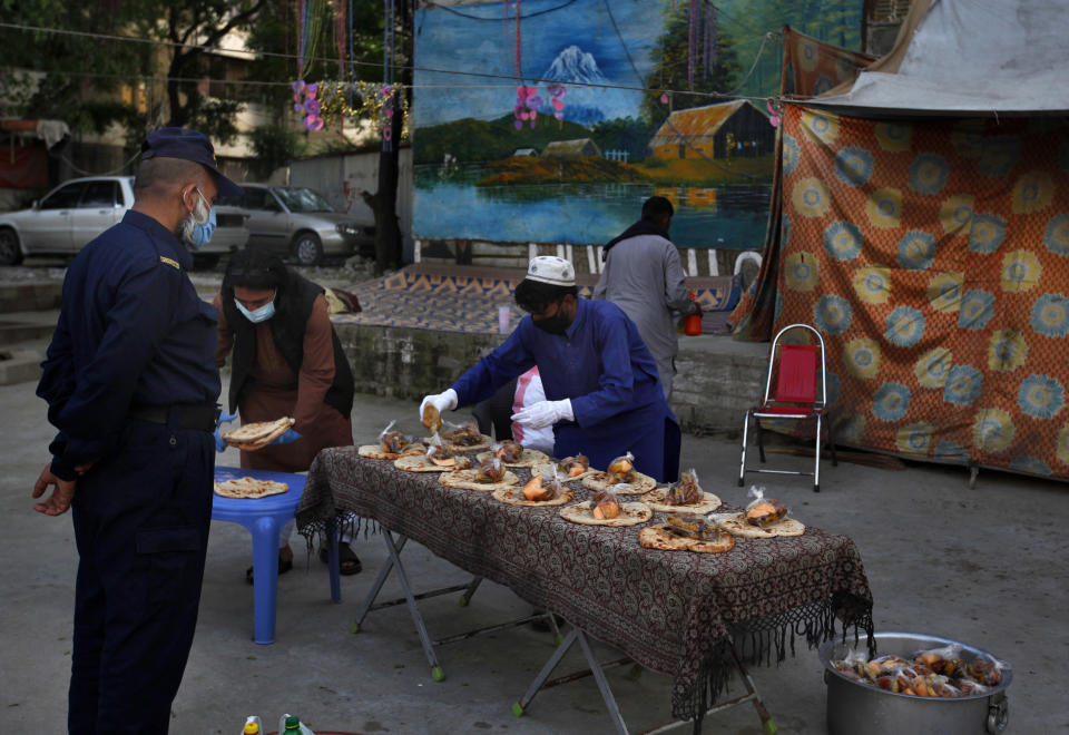 Volunteers arrange food to distribute to the needy for breaking their fast on the second day of Ramadan, in Islamabad, Pakistan. Sunday, April 26, 2020. Millions have started the Muslim fasting month Ramadan, the holiest month on the Islamic calendar, under the coronavirus lockdown or strict social restrictions. (AP Photo/Anjum Naveed)