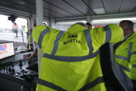 Britain's Prime Minister Boris Johnson dons safety clothing reading "Prime Minister" during a General Election campaign stop aboard a tog boat in the port of Bristol, England, Thursday, Nov. 14, 2019. Britain goes to the polls on Dec. 12. (AP Photo/Frank Augstein, Pool)