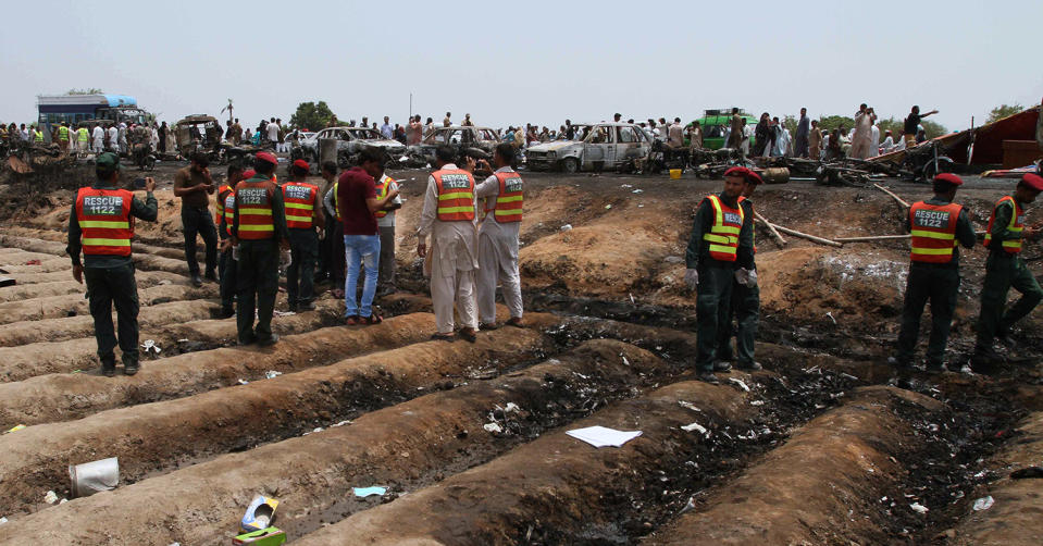 <p>Pakistani rescue workers gather at the site of an oil tanker explosion at a highway near Bahawalpur, Pakistan, Sunday, June 25, 2017. An overturned oil tanker burst into flames in Pakistan on Sunday, killing more than one hundred people who had rushed to the scene of the highway accident to gather leaking fuel, an official said. (AP Photo/Iram Asim) </p>