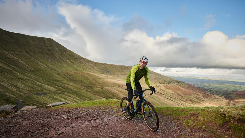 Image shows a person riding a budget gravel bike.