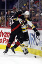 Carolina Hurricanes' Jesperi Kotkaniemi (82) collides with Boston Bruins' Charlie Coyle (13) during the first period of an NHL hockey game in Raleigh, N.C., Sunday, Jan. 29, 2023. (AP Photo/Karl B DeBlaker)