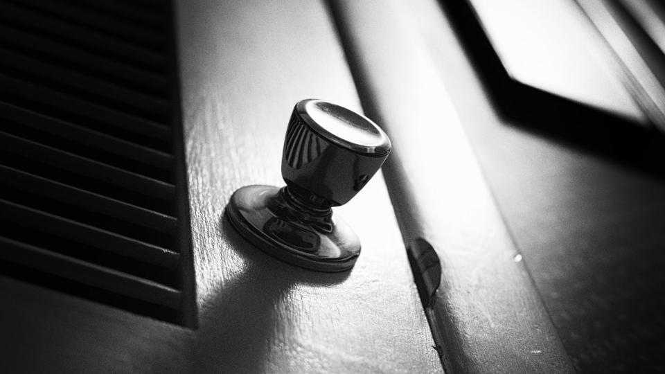 a dark, spooky grainy closet door in harsh black and white