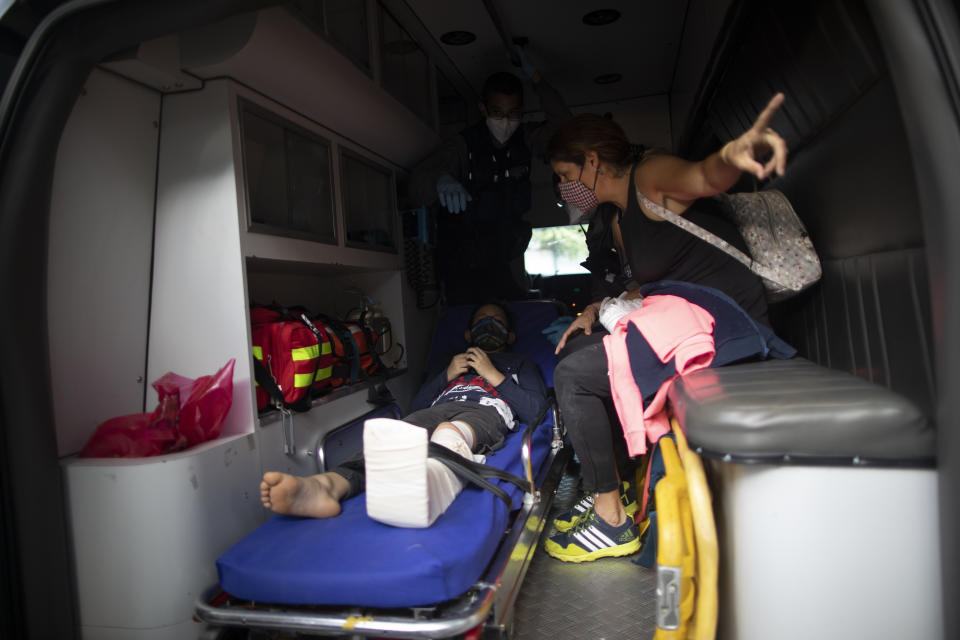 A boy who was involved in a motorcycle accident is transported to the hospital by Angels of the Road volunteer paramedics in their only ambulance in Caracas, Venezuela, Thursday, Feb. 4, 2021. The volunteer corps relies on donated medical supplies and funding from international organizations to provide much-needed emergency services, operating entirely independent of the government. (AP Photo/Ariana Cubillos)