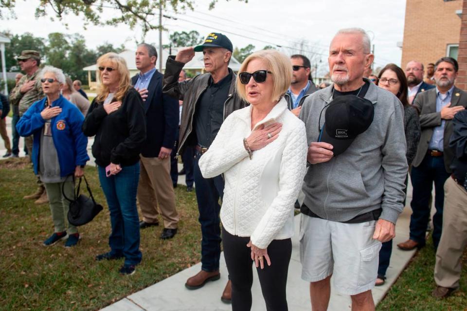 Members of the public say the pledge of allegiance during a ceremony dedicating commemorative stars in honor of Sergeant Steven Robin and Officer Branden Estorffe outside the new Bay St. Louis Police Department in Bay St. Louis on Thursday, Dec. 14, 2023. Estorffe and Robin were killed on Dec. 14, 2022 by a local veterinarian when they responded to a call at a Motel 6.