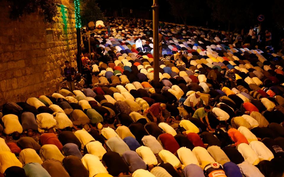 Palestinian Muslim worshippers pray outside Lion's Gate on Wednesday night - Credit: AFP