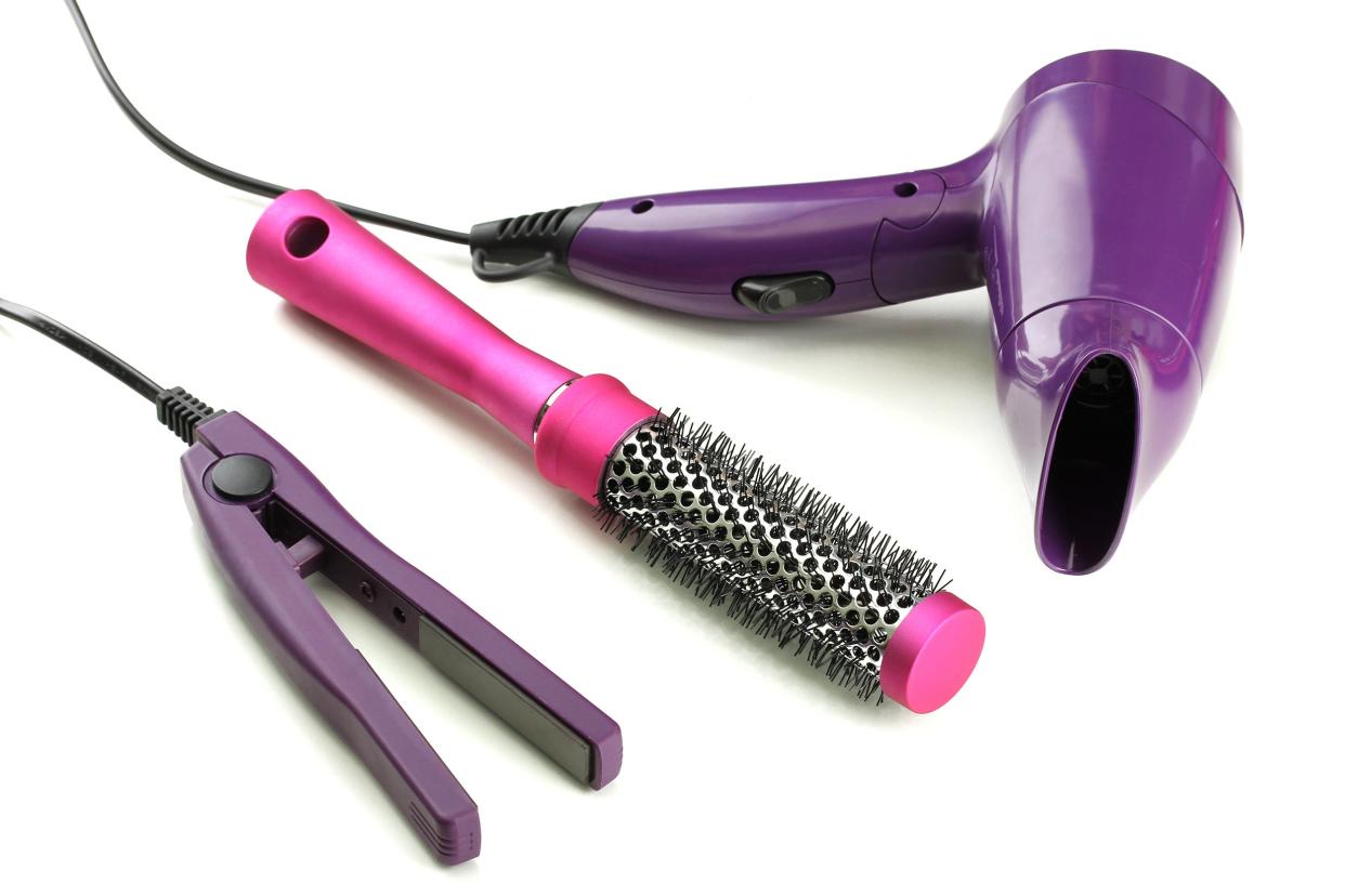 A hair dryer, brush, and hair straightener
