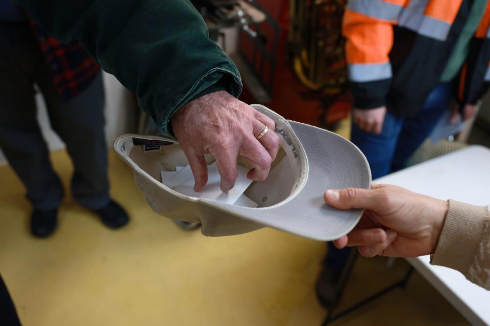 Republican caucus participants put votes into hat Monday, January 15, 2024, at Stofer Music Shop in Edin Township/Low Moor. (Amir Prellberg/Freelance)