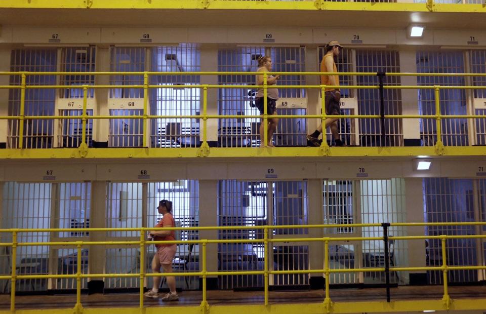 People walk by cells at the Cell Block 7 Prison Museum at the State Prison of Southern Michigan in Jackson, Mich., Saturday, June 28, 2014.