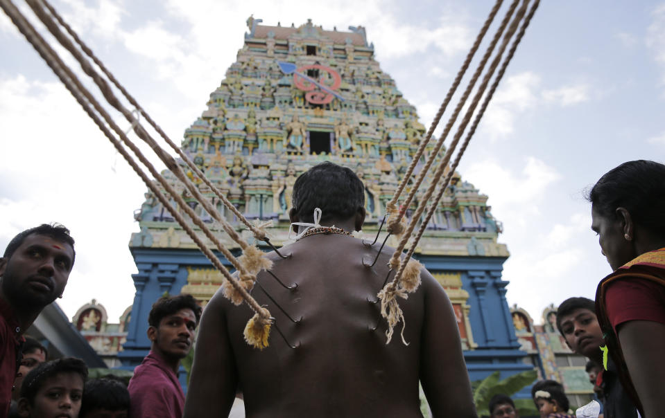 FILE - In this July 16, 2019 file photo, a Sri Lankan Hindu devotee stands with his body pierced with metal hooks as part of performing a ritual at a temple in Colombo, Sri Lanka. The Indian Ocean island nation of Sri Lanka, which will elect a new president on Saturday, Nov. 16, 2019 has had a tumultuous history. Since gaining independence from British colonial rule in 1948, the country has seen three major armed conflicts in which hundreds of thousands have died. It also has had its share of natural disasters. As it prepares to elect its seventh president, Sri Lanka remains a divided nation, with ethnic, political and economic issues unresolved. (AP Photo/Eranga Jayawardena, File)