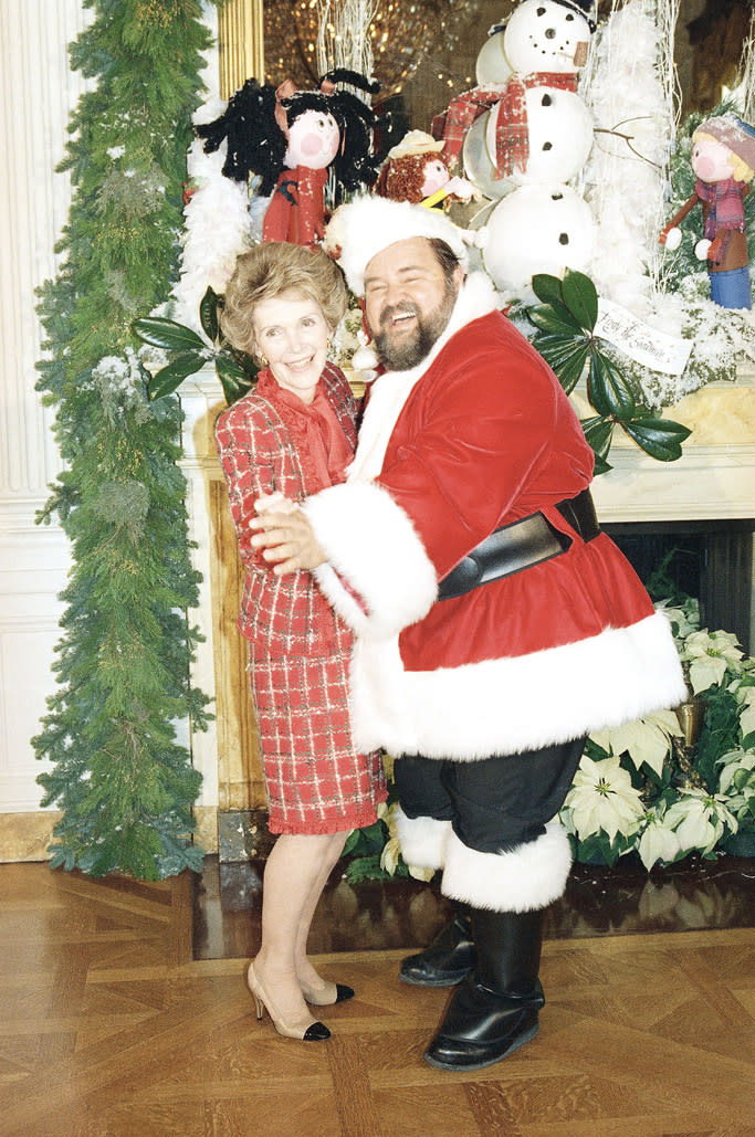 Nancy Reagan, clad in Chanel pumps, and actor Dom Deluise celebrate Christmas at the White House in 1987. - Credit: AP Images.