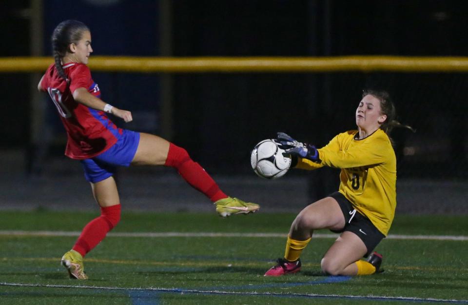 Rush-Henrietta goalkeeper Natalie Wood makes a save on a break away shot from Fairport's Savanna Biehler.